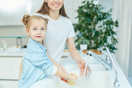 homeowner checking water softener brine tank salt level and system settings